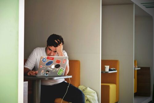 Man looking frustrated on laptop, illustrating poor user experience on a website.